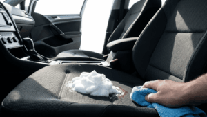 Rasierschaum auf einem dunklen Autositz zur Entfernung von Blutflecken.